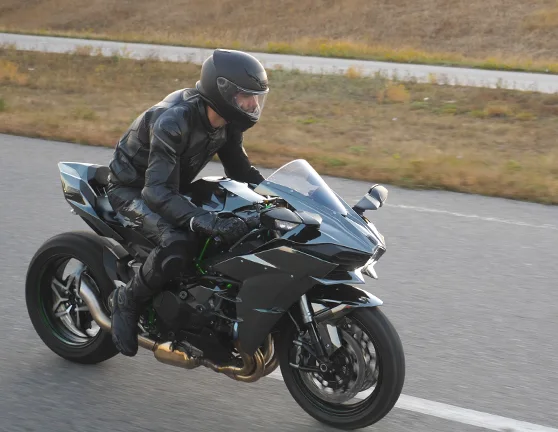 Motorista circulando con su moto por una carretera